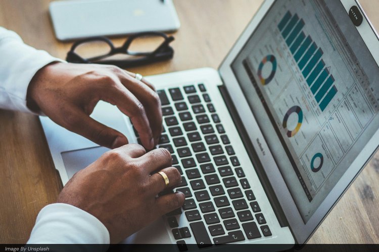 Close-up of hands typing on a laptop showing detailed analytics charts, bar graphs, and pie charts, representing data-driven keyword research, SEO performance tracking, and website traffic analysis for better rankings.