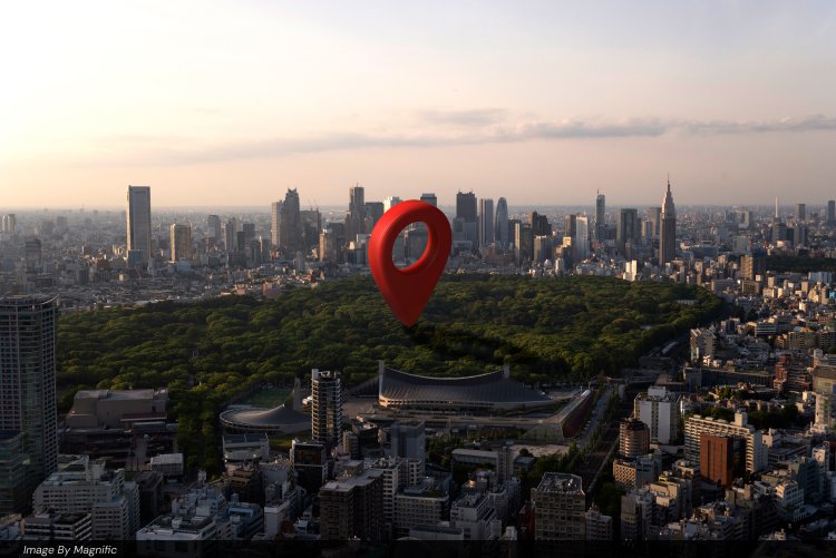 Red location pin marker floating above a dense city skyline, representing local search targeting